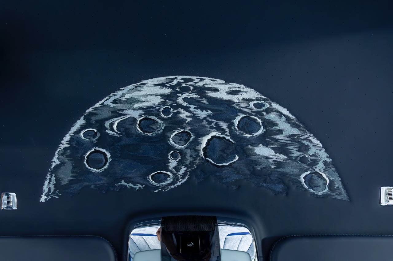 Embroidered moon artwork on a dark headliner
