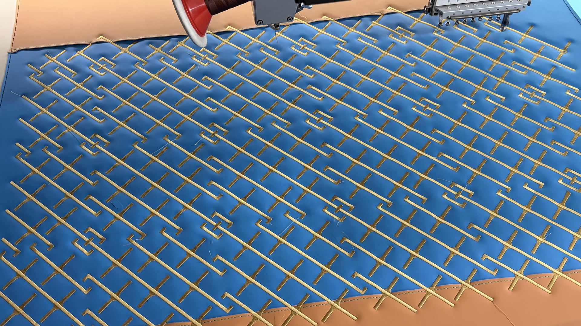 Gold geometric stitching on a blue panel for the Venuum project