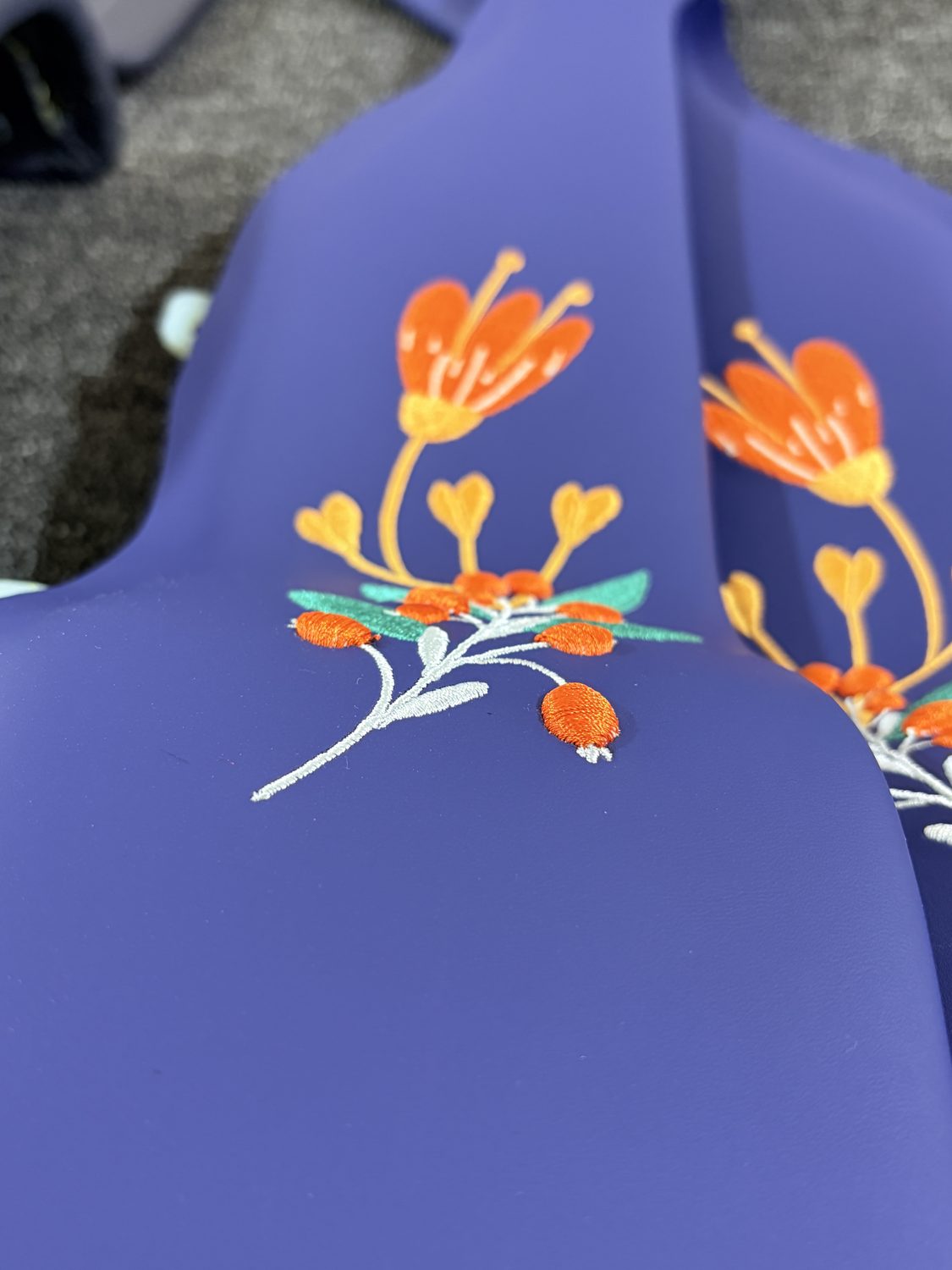 Floral embroidery on a blue panel